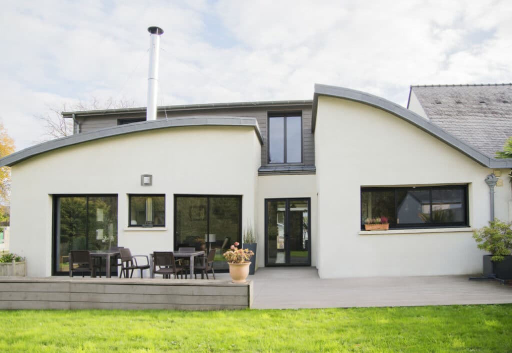 Maison avec baies vitrées et fenêtres PVC noir modernes.